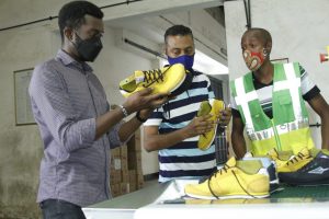 Enda Sportswear Lead Designer Cyprian Kiswili inspecting workers assembling shoe parts at Umoja Rubber (EPZ) Company in Kilifi County. Photo by Haniel Mengistu